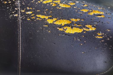 Hasarlı motosiklet koltuğu. Siyah motosiklet koltuğu deri koltuk yırtığı. Eski deri koltuk yok. Deri motosiklet koltuğunun dokusu ve arka planı zarar görmüş ya da yırtılmış. Kırık motosiklet ya da scooter koltuğu.