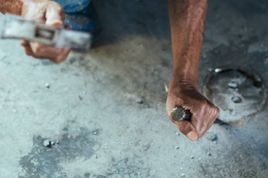 Su hizmetleri bakım servisinin yaşlı çalışanı evdeki kanalizasyon kanallarını değiştiriyor. Yaşlı adamın elleri kanalizasyon sisteminin lağım kapağını değiştirip onarıyor. Tuvalet drenaj sisteminin bakımı.