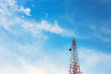 Mobil telefon kulesi, üs istasyonu ya da açık mavi gökyüzü arka planında ay olan tek kutup. Anten telekomünikasyon ve mavi gökyüzü arka planında gündüz Ay. Hilal şeklindeki telekomünikasyon kulesi..