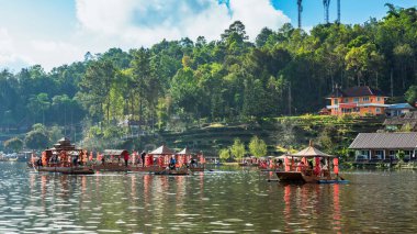 MAE HONG SON, THAILAND-DECEMBER 31,2024: Rak Thai Village Reservoir ya da Baan Rak Thai 'nin turistlerle dolu güzel manzarası ve antik Yunnan Çin tarzında bir göl manzaralı ahşap tekne alın