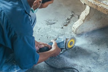 Su tesisatı bakım servisi evdeki kanalizasyon kanallarını değiştirmek için açılı öğütücü kullanıyor. Yaşlı adam kanalizasyon sisteminin lağım kapağını değiştirip onarıyor. Tuvalet drenaj sisteminin bakımı