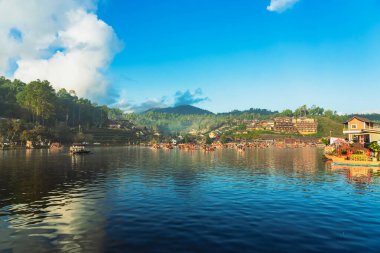 MAE HONG SON, THAILAND-DECEMBER 31,2024: Rak Thai Village Reservoir ya da Baan Rak Thai 'nin turistlerle dolu güzel manzarası ve antik Yunnan Çin tarzında bir göl manzaralı ahşap tekne alın