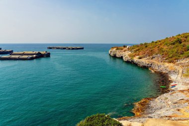 Denizde büyük bir yük mavnası. Adanın arkasındaki muson fırtınasından korunmak için demirli büyük bir römorkör. Römorkör kargosu ürünleri taşıyor. Mal taşıma ve gelişmekte olan ekonomide nehir taşımacılığının önemi.