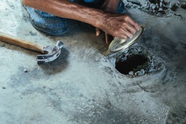 Su hizmetleri bakım servisinin yaşlı çalışanı evdeki kanalizasyon kanallarını değiştiriyor. Yaşlı adamın elleri kanalizasyon sisteminin lağım kapağını değiştirip onarıyor. Tuvalet drenaj sisteminin bakımı.