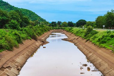 Çatlak beton duvardaki sulama kanalı veya sulama kanalı rezervuardan tarımsal alana su gönderir. River Ovası 'ndaki eski kırık sulama hendeği. Tarım sektöründe çevre felaketi.
