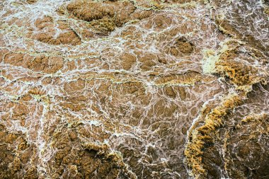 Kirli su bol bol akar. Nehir suyu bol bol akıyor. Sel suları, fırtına üstüne sel gibi akıyor. Çalkantılı nehir barajı. Baraj nedeniyle nehir türbülansı. Su Doğa DokusuName