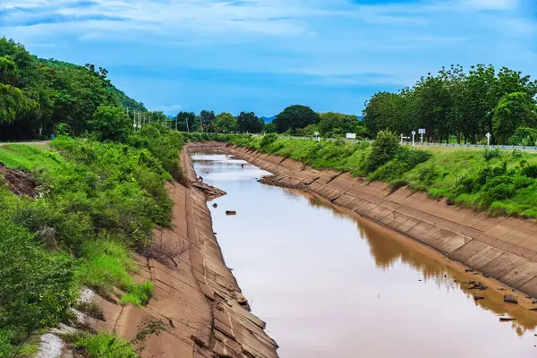 Çatlak beton duvardaki sulama kanalı veya sulama kanalı rezervuardan tarımsal alana su gönderir. River Ovası 'ndaki eski kırık sulama hendeği. Tarım sektöründe çevre felaketi.