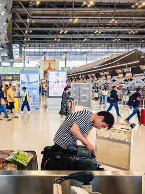 BANGKOK, THAILAND-SEPTEMBER 28, 2024: Tanımlanamayan Turistler, Suvarnabhumi Havaalanı 'ndan uçağa binmeden önce X-ray güvenlik taraması için bavullarındaki eşyaları kontrol edin ve paketleyin..