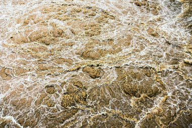 Kirli su bol bol akar. Nehir suyu bol bol akıyor. Sel suları, fırtına üstüne sel gibi akıyor. Çalkantılı nehir barajı. Baraj nedeniyle nehir türbülansı. Su Doğa DokusuName