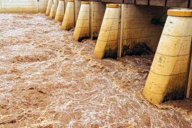 Kirli su bol bol akar. Nehir suyu bol bol akıyor. Sel suları, fırtına üstüne sel gibi akıyor. Çalkantılı nehir barajı. Baraj nedeniyle nehir türbülansı. Su Doğa DokusuName