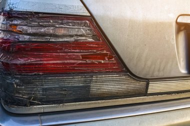 Arabanın stop lambası kırılmış ve şeffaf bantla kapatılmış. Kırık araba durdurma sinyali selobant ile tamir edildi. Hasarlı arabanın arka lambası kazara kırılmış ve şeffaf koli bandıyla kapatılmış.