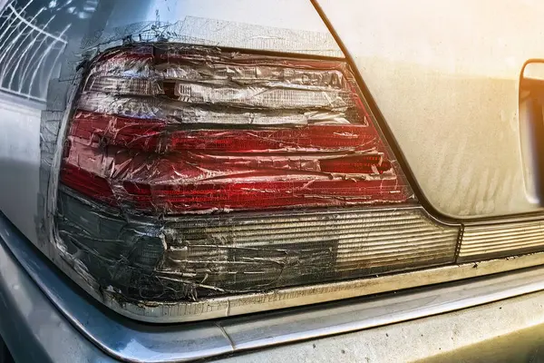 Arabanın stop lambası kırılmış ve şeffaf bantla kapatılmış. Kırık araba durdurma sinyali selobant ile tamir edildi. Hasarlı arabanın arka lambası kazara kırılmış ve şeffaf koli bandıyla kapatılmış.