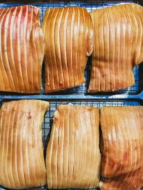 Güneşte kuruması için tepside duran çizik derili domuz göbeği, jelatinimsi katmanlar ve altın tonlarını gösteriyor. Yemek pişirme ya da yemek hazırlama konsepti için ideal. Lezzetli gevrek domuz eti yapma süreci.