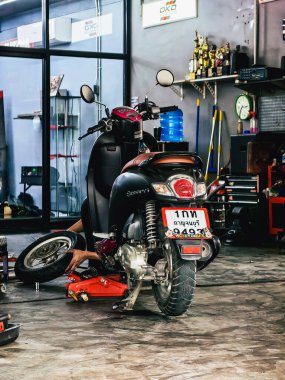 KANCHANABURI-THAILAND, 7 Kasım 2024 Honda motorsiklet atölyesi ve satış merkezi. LoHengMong tamirhanesinde teknisyen Honda motorsikletini tamir ediyor. Honda Motosiklet Tamir Bölümü.