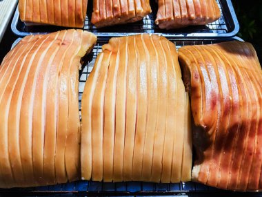 Güneşte kuruması için tepside duran çizik derili domuz göbeği, jelatinimsi katmanlar ve altın tonlarını gösteriyor. Yemek pişirme ya da yemek hazırlama konsepti için ideal. Lezzetli gevrek domuz eti yapma süreci.