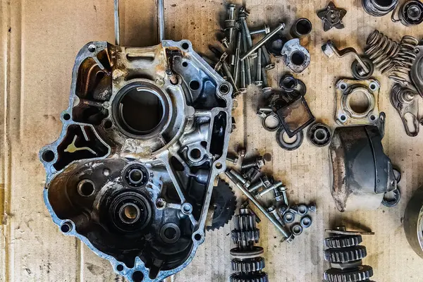 Motosiklet arka planının eski parçaları. Motorun eski parçalarını onar ve onar. Eski motosiklet yedek parçaları kıvrımlı kağıt arka planda. Yedek parçaların, teçhizatın, diferansiyelin, motorun, eski.