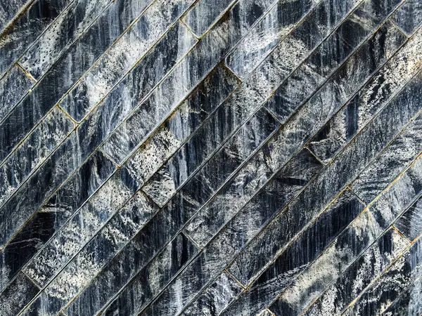 Çağdaş ve lüks şekilli mermer tuğla duvar desenli arka plan ve akış suyu. Taş duvarda granit duvar kağıtlarından yapılmış dekoratif su akışı. Dikdörtgen kaplamalı desenli duvar.