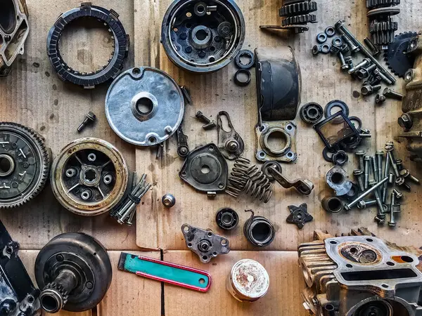 Motosiklet arka planının eski parçaları. Motorun eski parçalarını onar ve onar. Eski motosiklet yedek parçaları kıvrımlı kağıt arka planda. Yedek parçaların, teçhizatın, diferansiyelin, motorun, eski.