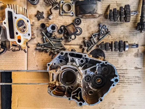 Motosiklet arka planının eski parçaları. Motorun eski parçalarını onar ve onar. Eski motosiklet yedek parçaları kıvrımlı kağıt arka planda. Yedek parçaların, teçhizatın, diferansiyelin, motorun, eski.