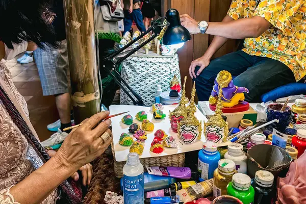 BANGKOK, THAILAND-APRIL 15, 2024: Sanatçı Tayland antik geleneksel Minyatür Khon maskesi veya Hua Khon eşsiz bir Tayland el işi ürünüdür, Değerli Hediyeler, İkon Siyam 'da Turizm Faaliyetleri-Görüntü.