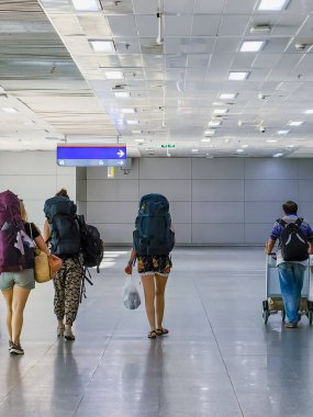 Sırt çantalı beyaz kadın yolcular terminalden biniş kapısına doğru yürüyorlar. Genç bayan sırt çantalı arkadaşlar tren istasyonunda yürürken tren yolculuğu için bekliyorlar. Seyahat ve macera konsepti.