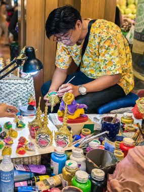 BANGKOK, THAILAND-APRIL 15, 2024: Sanatçı Tayland antik geleneksel Minyatür Khon maskesi veya Hua Khon eşsiz bir Tayland el işi ürünüdür, Değerli Hediyeler, İkon Siyam 'da Turizm Faaliyetleri-Görüntü.