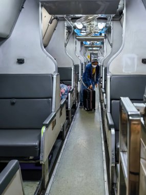 BANGKOK, THAILAND-NOVEMBER 26, 2023: Kimliği belirsiz yaşlı kadın yolcu trenle seyahat ediyor ve bagajlarını Krung Thep Terminal İstasyonu 'ndaki bagaj bölmesinde saklıyor..