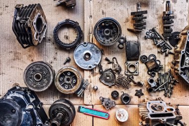 Motosiklet arka planının eski parçaları. Motorun eski parçalarını onar ve onar. Eski motosiklet yedek parçaları kıvrımlı kağıt arka planda. Yedek parçaların, teçhizatın, diferansiyelin, motorun, eski.