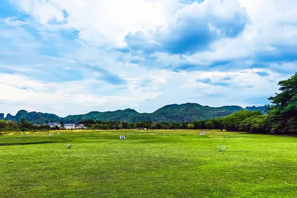 Golf sahası manzarası çimenli yamaçlar, doğal çitleri ve dağı olan uzaklık işaretleri. Mesafe işaretlerini gösteren atış poligonu. Golf ve golf sahasında bahçe işaretleri.
