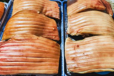 Güneşte kuruması için tepside duran çizik derili domuz göbeği, jelatinimsi katmanlar ve altın tonlarını gösteriyor. Yemek pişirme ya da yemek hazırlama konsepti için ideal. Lezzetli gevrek domuz eti yapma süreci.