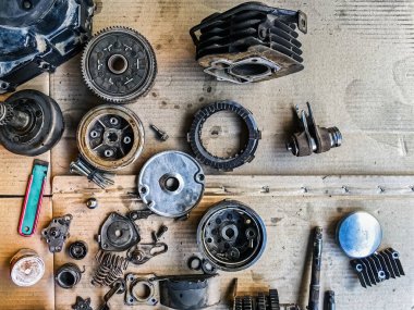 Motosiklet arka planının eski parçaları. Motorun eski parçalarını onar ve onar. Eski motosiklet yedek parçaları kıvrımlı kağıt arka planda. Yedek parçaların, teçhizatın, diferansiyelin, motorun, eski.