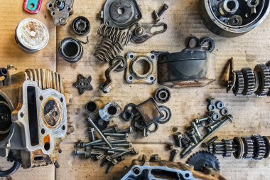 Motosiklet arka planının eski parçaları. Motorun eski parçalarını onar ve onar. Eski motosiklet yedek parçaları kıvrımlı kağıt arka planda. Yedek parçaların, teçhizatın, diferansiyelin, motorun, eski.