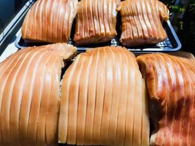 Güneşte kuruması için tepside duran çizik derili domuz göbeği, jelatinimsi katmanlar ve altın tonlarını gösteriyor. Yemek pişirme ya da yemek hazırlama konsepti için ideal. Lezzetli gevrek domuz eti yapma süreci.