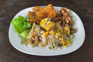 Kızarmış pilav eriştesi ve kızarmış tavuk taze marul ve acı biber sosuyla servis edilir. Yakın plan kızarmış pirinç eriştesi ve tavuk ve yumurta. Asya yemeği tarzı. Lezzetli Tayland yemekleri.