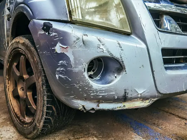 Hasarlı sis lambası lensine yakın ve ön tampondaki boyayı çatlatmış ve soymuş. Araba tamponu derin boya hasarıyla çizilmiş. Dent çizik arabası. Kazara kırık bir araba. Araba çarpması yüzünden kırışıklıklar.