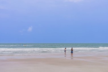 Sahilde cep telefonu kullanan mutlu ve kaygısız kadınlar. Deniz kenarında akıllı telefon kullanan kadın arkadaşlar. Güzel, güzel iki kadın sahilde vakit geçiriyor. Seyahat, turizm ve tatil kavramı.