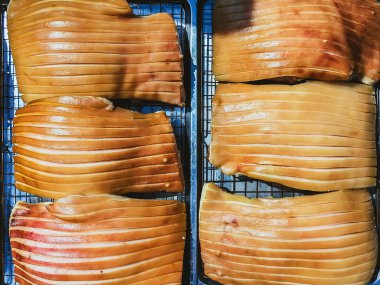 Güneşte kuruması için tepside duran çizik derili domuz göbeği, jelatinimsi katmanlar ve altın tonlarını gösteriyor. Yemek pişirme ya da yemek hazırlama konsepti için ideal. Lezzetli gevrek domuz eti yapma süreci.