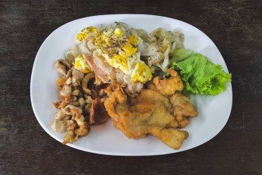 Kızarmış pilav eriştesi ve kızarmış tavuk taze marul ve acı biber sosuyla servis edilir. Yakın plan kızarmış pirinç eriştesi ve tavuk ve yumurta. Asya yemeği tarzı. Lezzetli Tayland yemekleri.