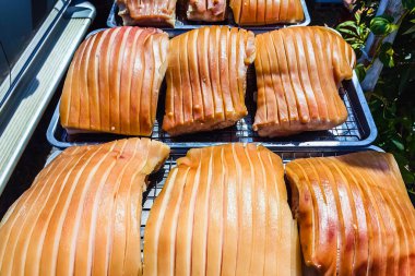 Güneşte kuruması için tepside duran çizik derili domuz göbeği, jelatinimsi katmanlar ve altın tonlarını gösteriyor. Yemek pişirme ya da yemek hazırlama konsepti için ideal. Lezzetli gevrek domuz eti yapma süreci.