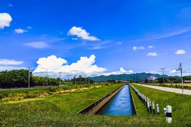Beton duvardaki sulama kanalı veya sulama kanalı rezervuardan tarımsal alana su gönderir. Güzel kırsal manzaralı su tedarik sistemi için kanal sistemi. Akan suyu olan kanal.