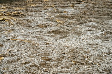 Kirli su bol bol akar. Nehir suyu bol bol akıyor. Sel suları, fırtına üstüne sel gibi akıyor. Çalkantılı nehir barajı. Baraj nedeniyle nehir türbülansı. Su Doğa DokusuName
