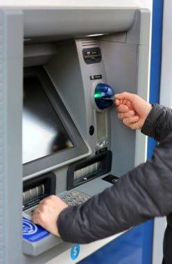 ATM Otomatik Teller Machine 'de kredi kartıyla işlem yapan bir adam.