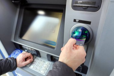 ATM Otomatik Teller Machine 'de kredi kartıyla işlem yapan bir adam.