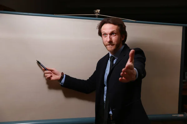 stock image The bearded businessman with a white screen behind him shows his reaction to the audience during the presentation