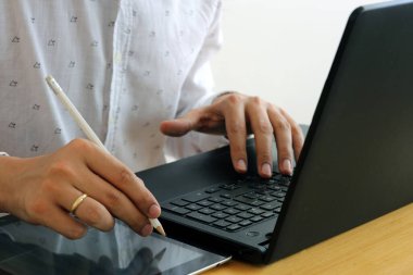 Bir iş adamı bir projeyi, online ticareti veya görevi tamamlamak için tablet ve dizüstü bilgisayar kullanır.