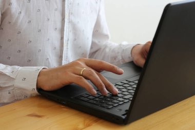 Bilgisayarla hesaplama yapan beyaz gömlekli bir çalışan. 