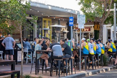 Brisbane, Queensland, Avustralya - Ağustos 2022: Pazar sabahı kahvaltısı için bir açık kafe kaldırımında yemek yiyen insanlar.