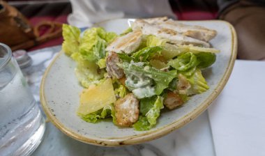 Marul ve sosla birlikte bir restoranda tavuklu salata.