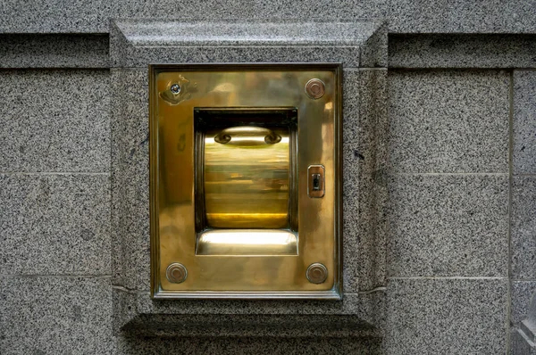 A brass after hours banking deposit box in the street of an Australian city