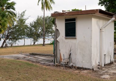 Okyanus kıyısındaki yıpranmış kulübede hasar ve enkaz var.